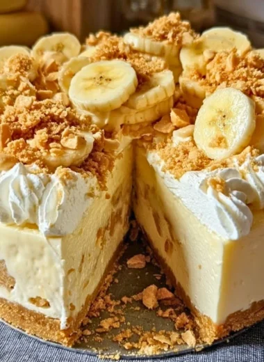 Delicious Banana Pudding Crunch Cheesecake topped with whipped cream and bananas