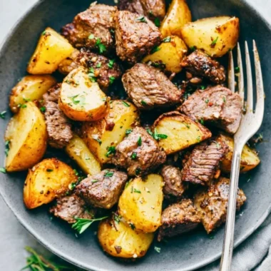 Garlic butter steak bites served with roasted potatoes on a plate