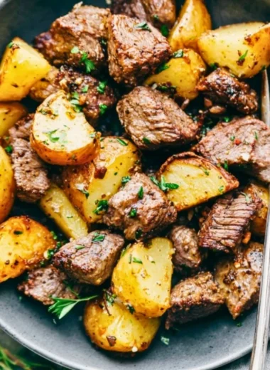 Garlic butter steak bites served with roasted potatoes on a plate