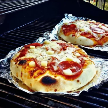 Delicious grilled pizza on a barbecue grill with fresh toppings.