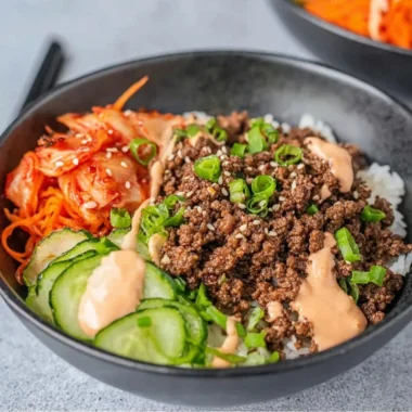 Korean beef rice bowl topped with sesame seeds and green onions