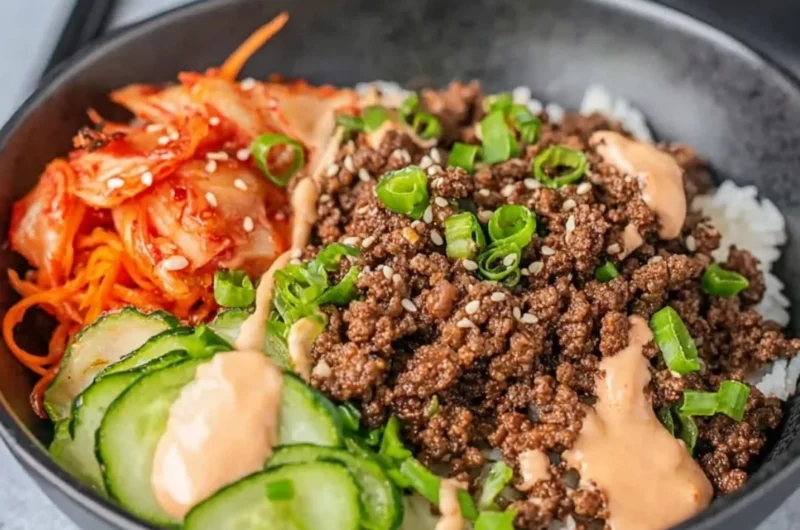 Korean beef rice bowl topped with sesame seeds and green onions