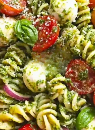 Pesto pasta salad with tomatoes and mozzarella served in a bowl