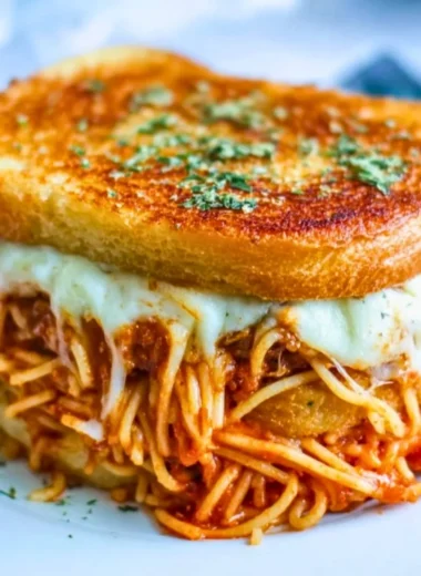 Delicious spaghetti grilled cheese sandwich prepared with gooey melted cheese.