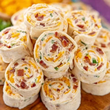 Colorful potluck pinwheels filled with vegetables and cream cheese on a platter.