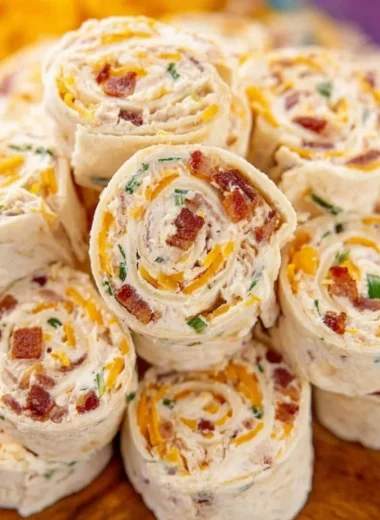 Colorful potluck pinwheels filled with vegetables and cream cheese on a platter.