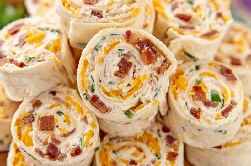 Colorful potluck pinwheels filled with vegetables and cream cheese on a platter.