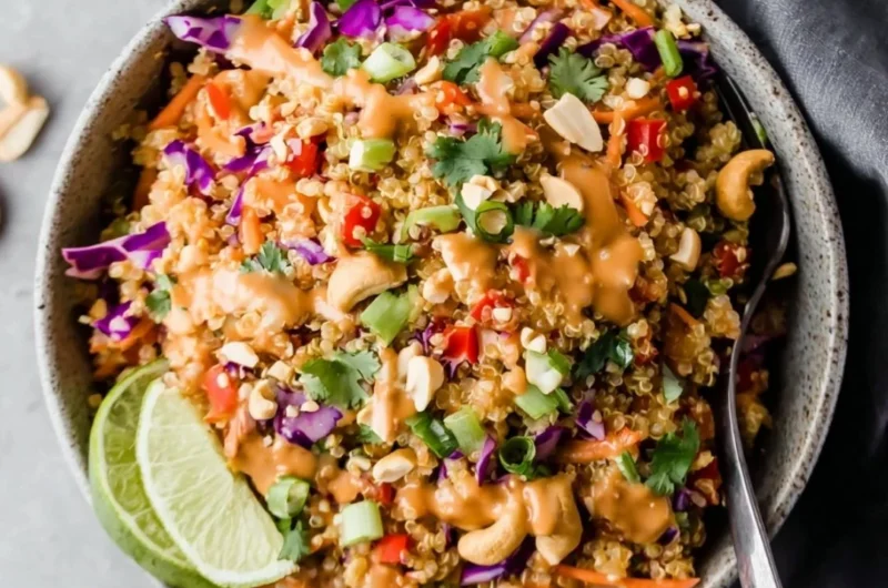 Thai-inspired quinoa salad with creamy peanut ginger dressing on a plate.