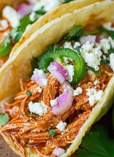 Delicious authentic Chicken Tinga served in a bowl with cilantro and lime