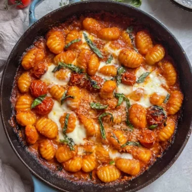 Creamy tomato gnocchi served in a bowl garnished with basil.