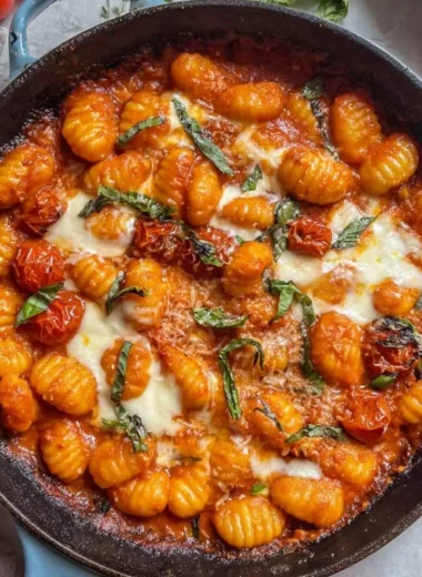 Creamy tomato gnocchi served in a bowl garnished with basil.