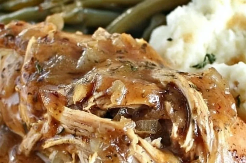 Crock Pot Mississippi Chicken served on a plate with herbs and sides