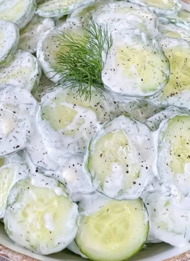 Cucumber Salad with mayo and sour cream in a bowl garnished with herbs