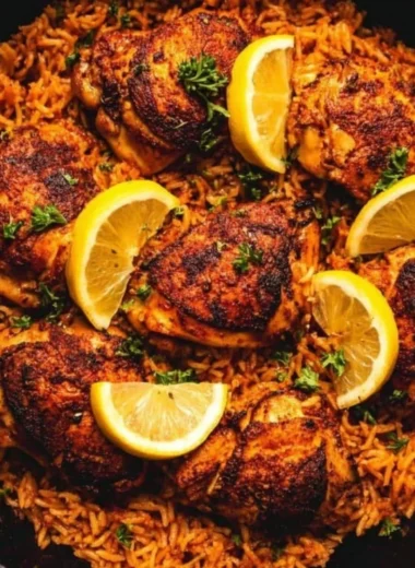 One pan Spanish chicken with rice garnished with fresh herbs and colorful vegetables.