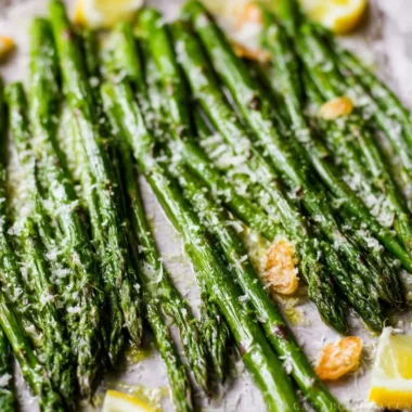 Oven roasted Garlic Parmesan asparagus on a plate garnished with parsley.