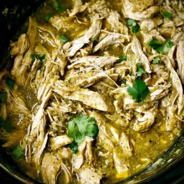 Slow cooker chicken with green sauce garnished with fresh herbs