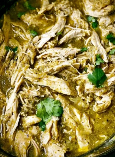 Slow cooker chicken with green sauce garnished with fresh herbs