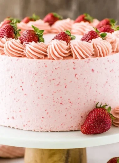 Delicious homemade strawberry cake topped with fresh strawberries and cream