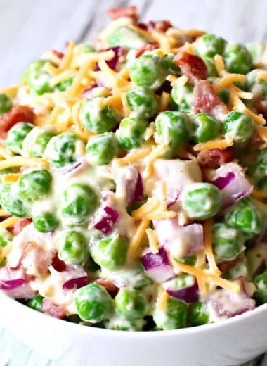 Delicious pea salad with fresh peas, herbs, and dressing served in a bowl.