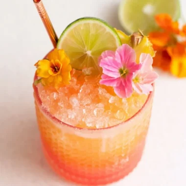 Colorful pineapple mango rum punch in a glass garnished with fruit