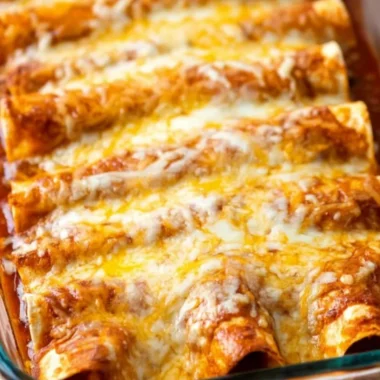 Plate of delicious restaurant-style red cheese enchiladas topped with sauce