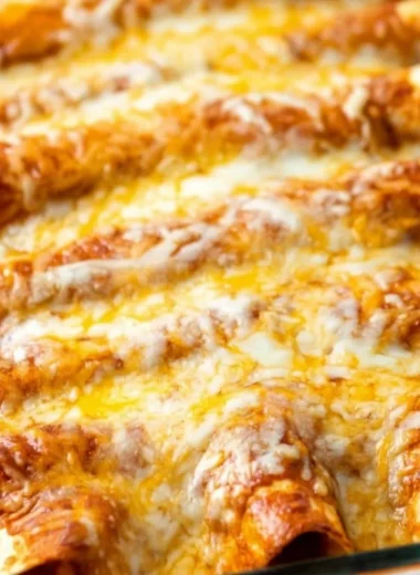 Plate of delicious restaurant-style red cheese enchiladas topped with sauce