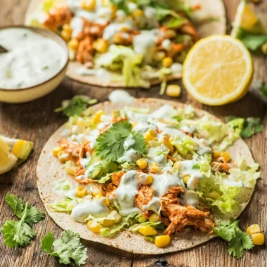 Skinny Buffalo Chicken Tacos topped with fresh ingredients and served on a plate