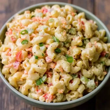 Bowl of delicious small homemade macaroni salad with fresh vegetables and dressing
