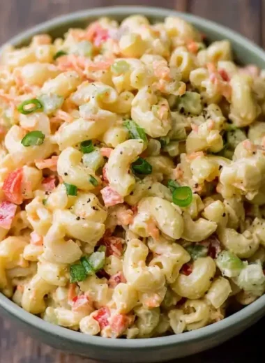 Bowl of delicious small homemade macaroni salad with fresh vegetables and dressing