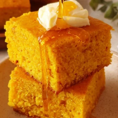 Delicious sweet potato cornbread served on a wooden board with butter on top.