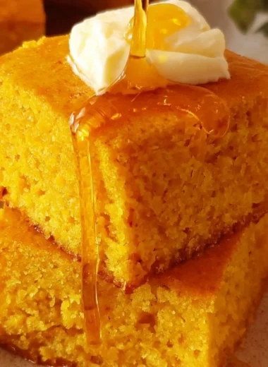 Delicious sweet potato cornbread served on a wooden board with butter on top.