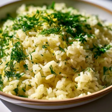 Authentic Greek lemon rice served in a bowl with fresh herbs and lemon slices.