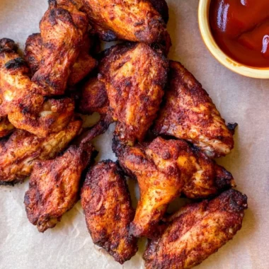 Delicious Traeger smoked chicken wings ready to serve at a backyard barbecue.