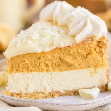 Cozy eggnog pumpkin cheesecake topped with whipped cream and cinnamon