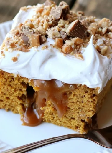 Caramel Pumpkin Poke Cake topped with caramel sauce and whipped cream