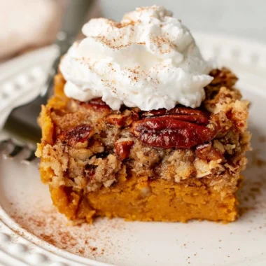 Homemade cozy pumpkin dump cake served with whipped cream