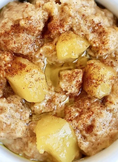 Bowl of homemade stovetop apple cinnamon oatmeal topped with fresh apples