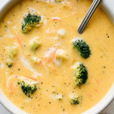 Bowls of creamy Broccoli Cheddar Soup garnished with fresh broccoli and cheese.