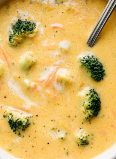 Bowls of creamy Broccoli Cheddar Soup garnished with fresh broccoli and cheese.