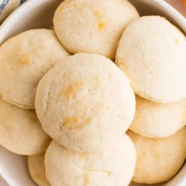 Freshly baked orange whipped shortbread cookies on a cooling rack