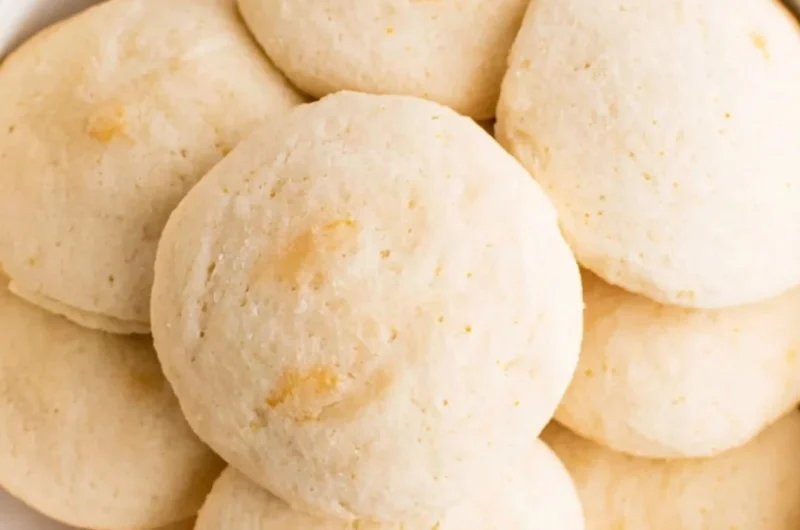 Freshly baked orange whipped shortbread cookies on a cooling rack